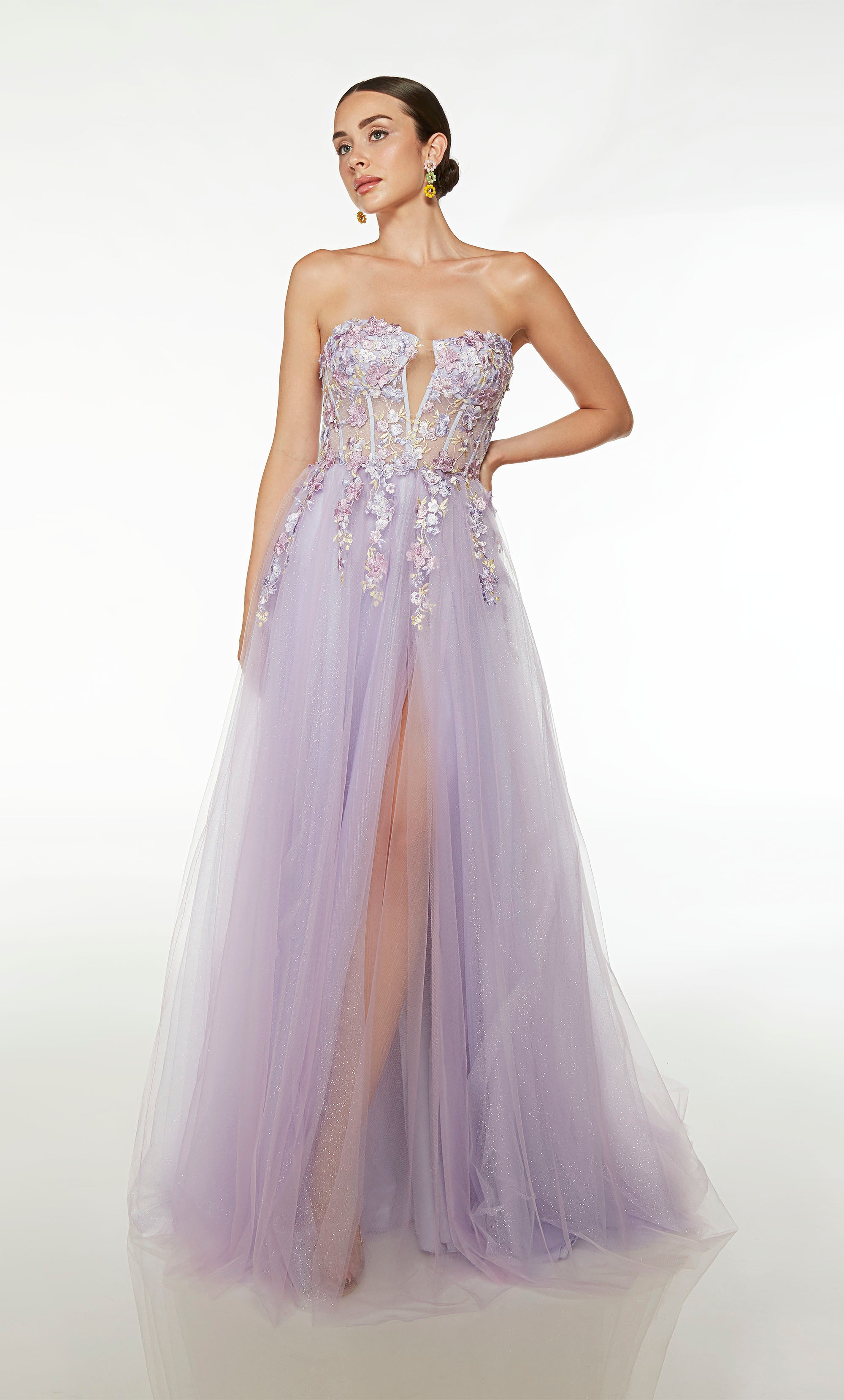 Dreamy lilac purple corset dress with sheer bodice, floral lace appliques, glitter tulle skirt, side slit, lace-up back, and trailing train for an magical touch.