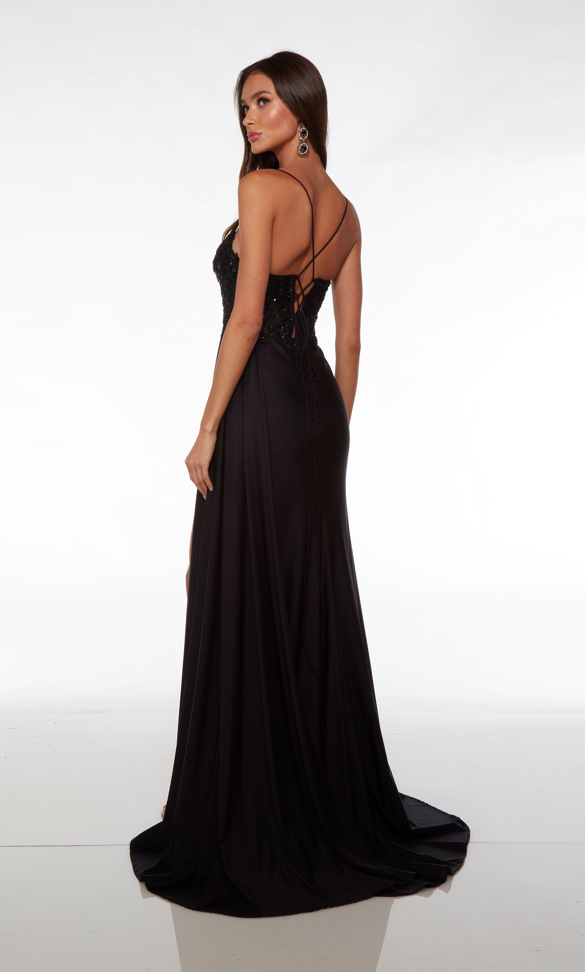 Chic black formal gown: scooped plunging neckline, spaghetti straps, sheer lace bodice, rhinestone-trimmed high slit, crisscross lace-up back, and train.
