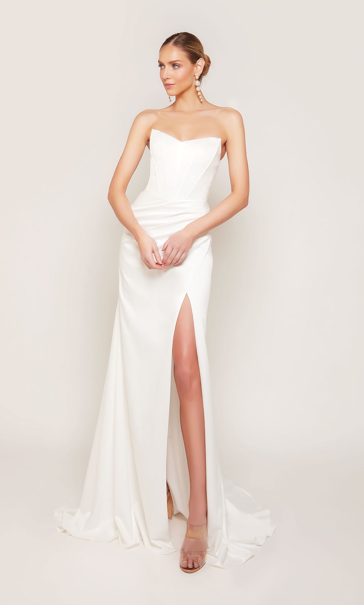 A strapless, corset wedding dress with a ruched waist, an elegant side slit, and detachable side train for a dramatic effect.