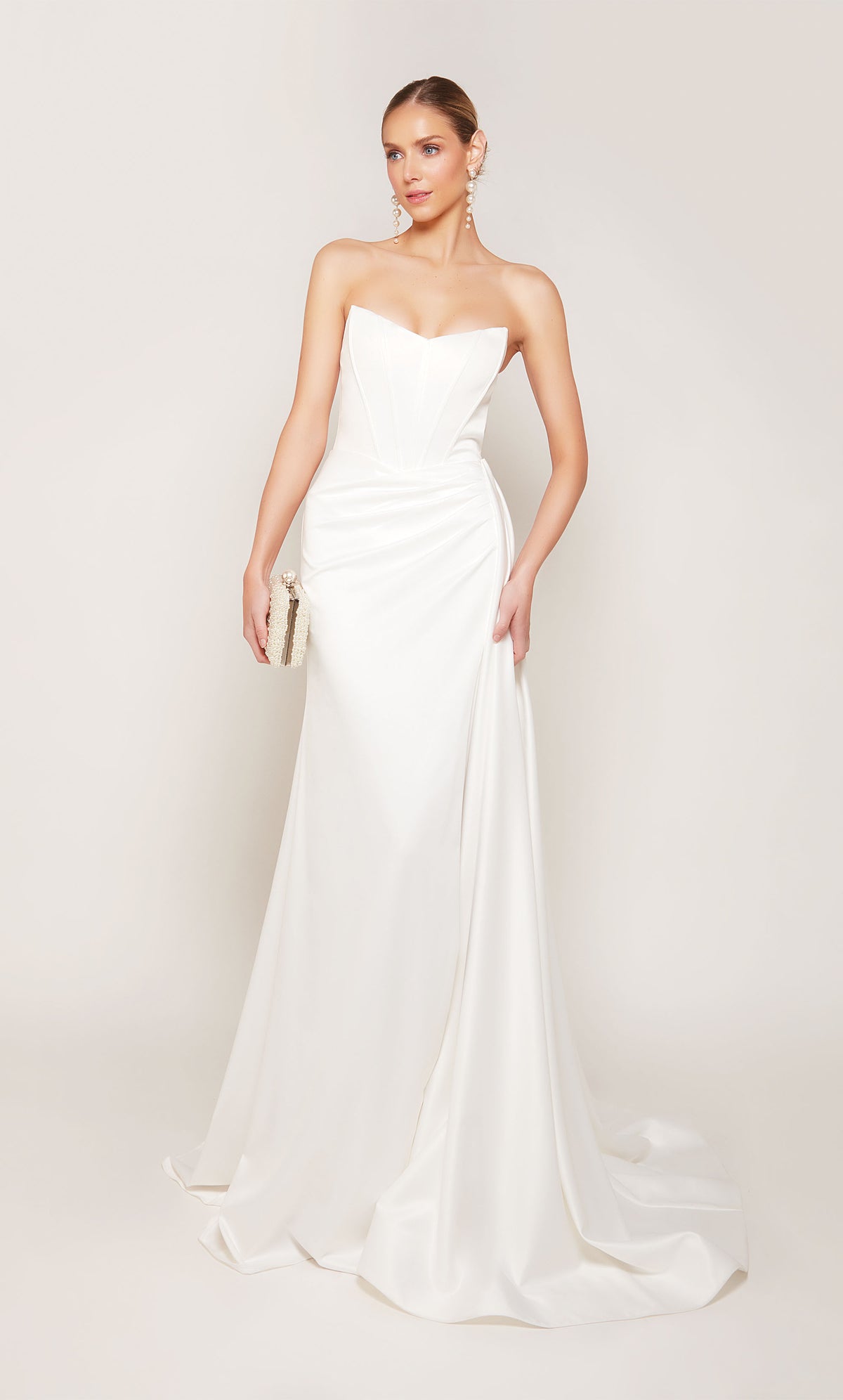 A strapless, corset wedding dress with a ruched waist, an elegant side slit, and detachable side train for a dramatic effect.