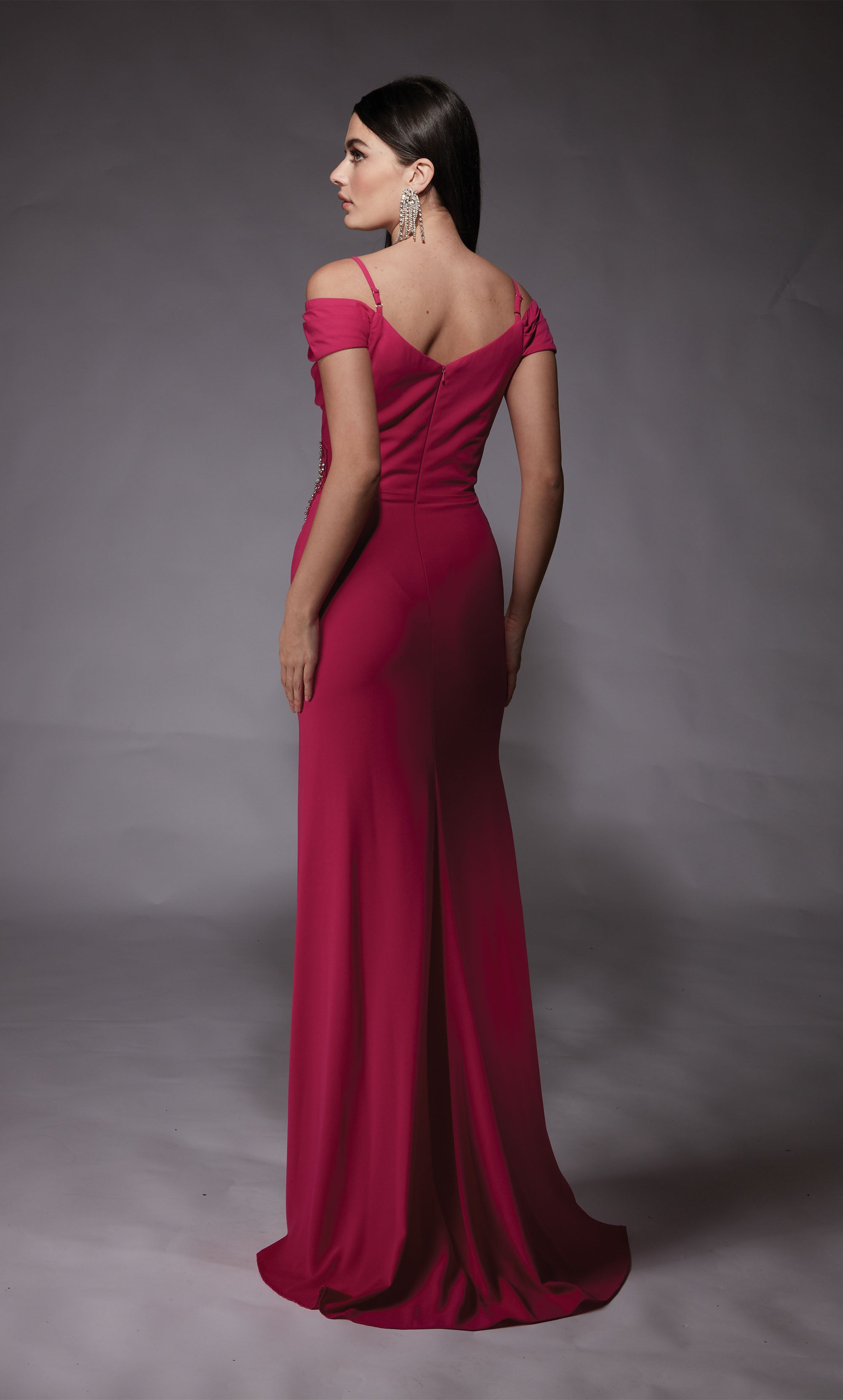 A hot pink, off-the-shoulder, mother-of-the-bride dress with adjustable spaghetti straps and a side slit. The back has a zip-up closure and a slight train.