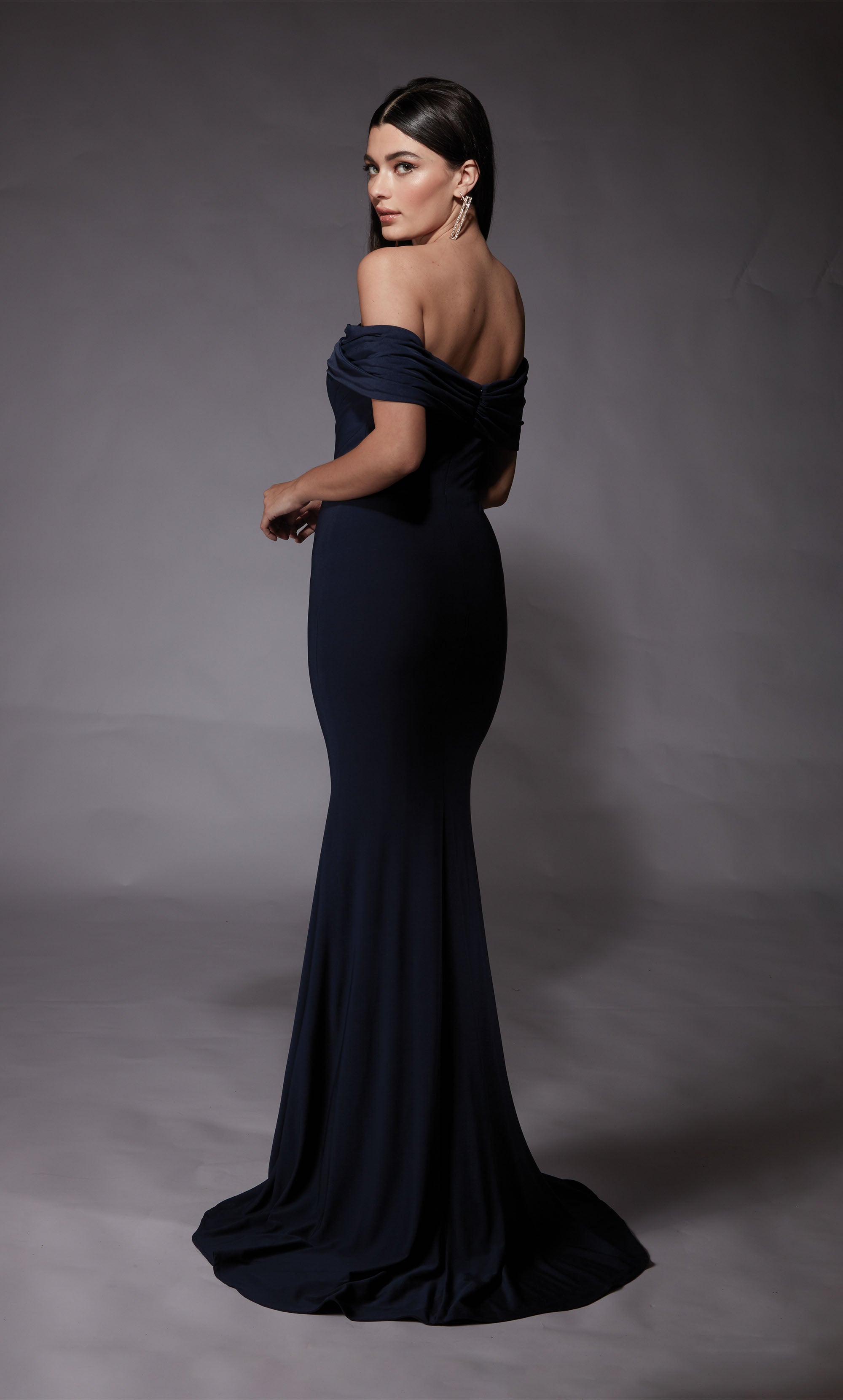 A navy evening gown with an off the shoulder neckline and fit an flare silhouette. The dress was crafted from a gorgeous Italian Jersey fabric.