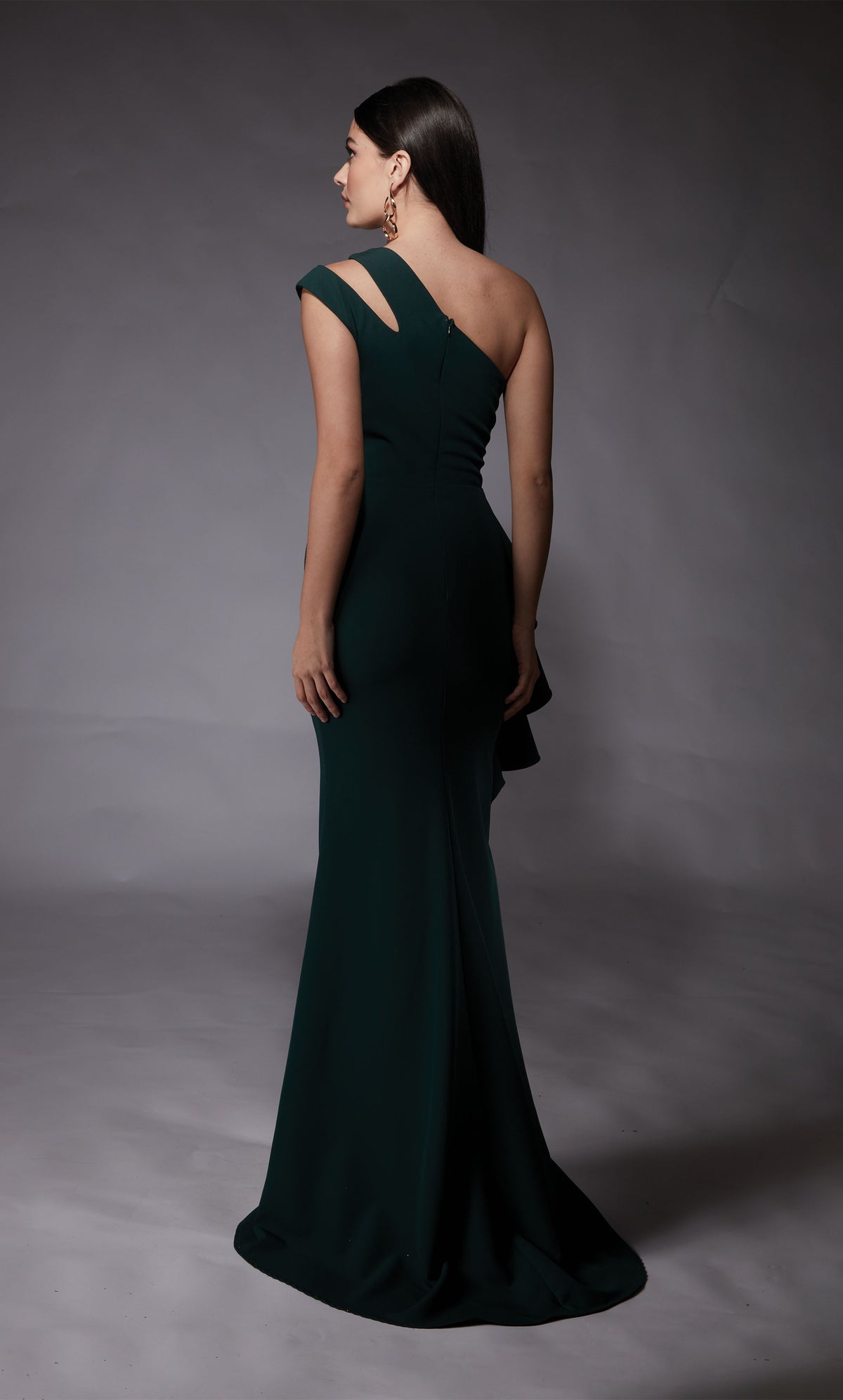Forest green long evening gown highlighting a cutout, one shoulder neckline, a zip-up back, and slight train.