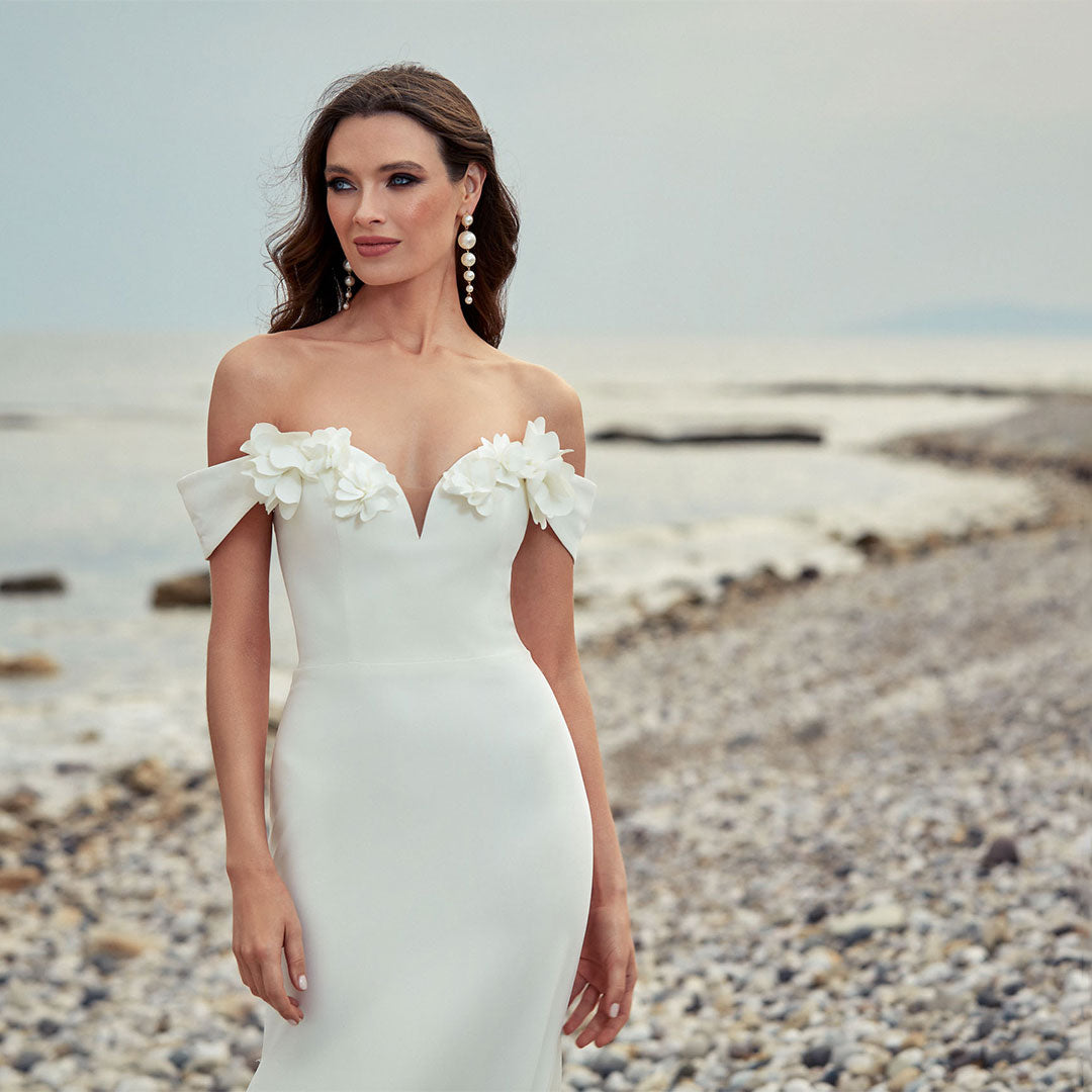 Simple wedding gown with an off the shoulder neckline in ivory.