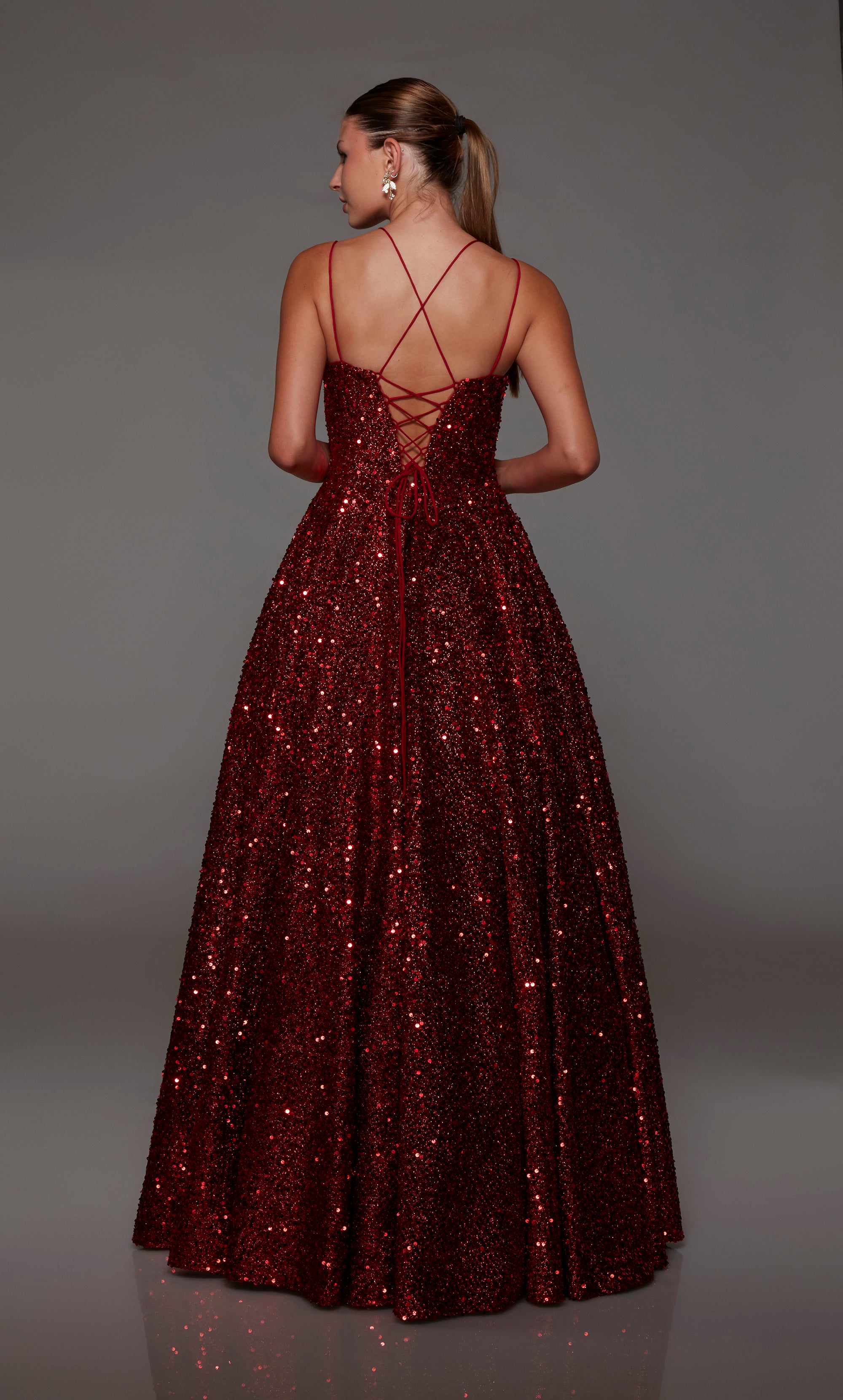 Elegant red A-line prom dress with an V-neck, adorned with sequins, dual straps, and an charming lace-up back.