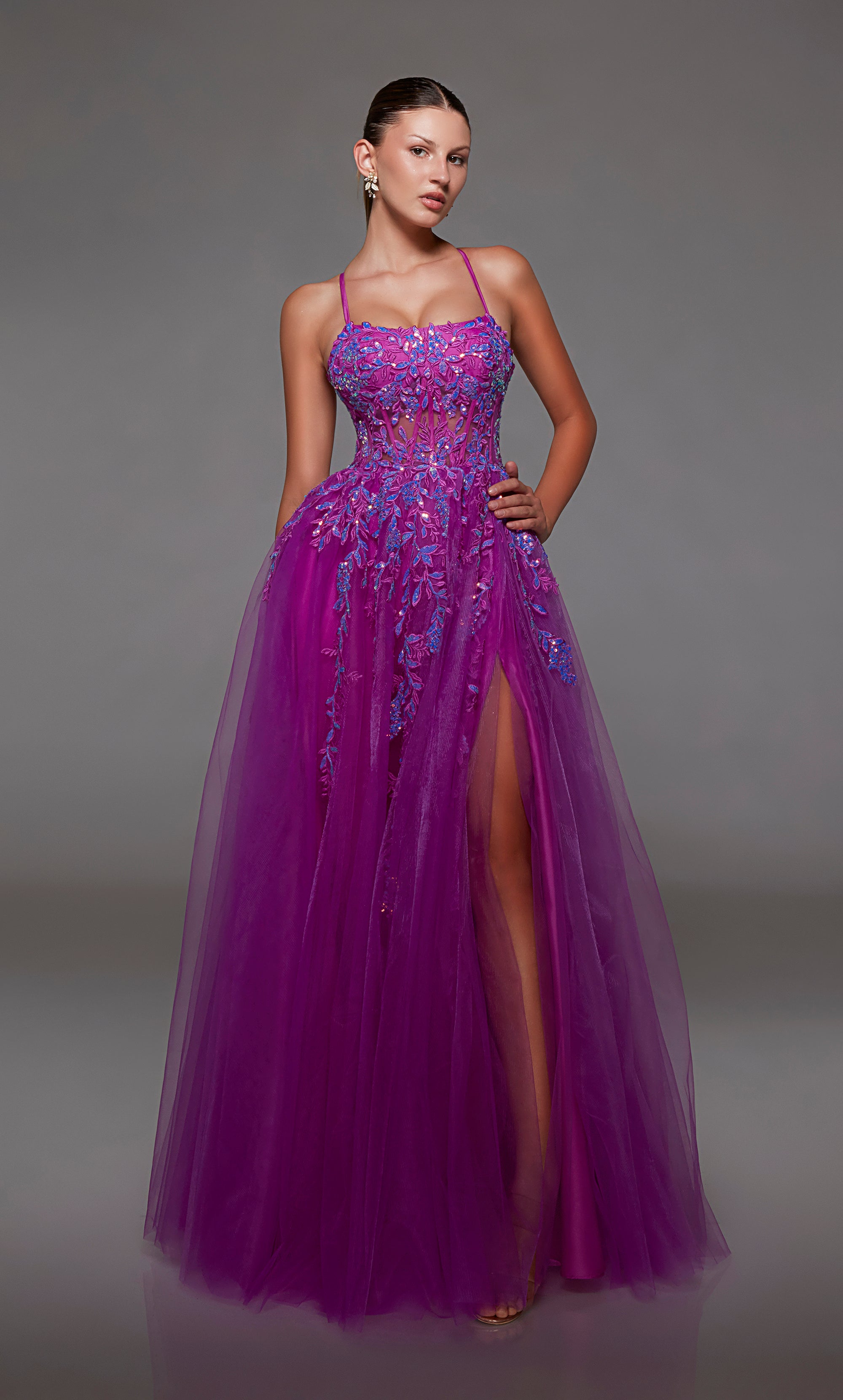 Purple prom dress: sheer corset bodice, full tulle skirt with front slit, lace-up back, and intricate floral lace appliques for an enchanting look.