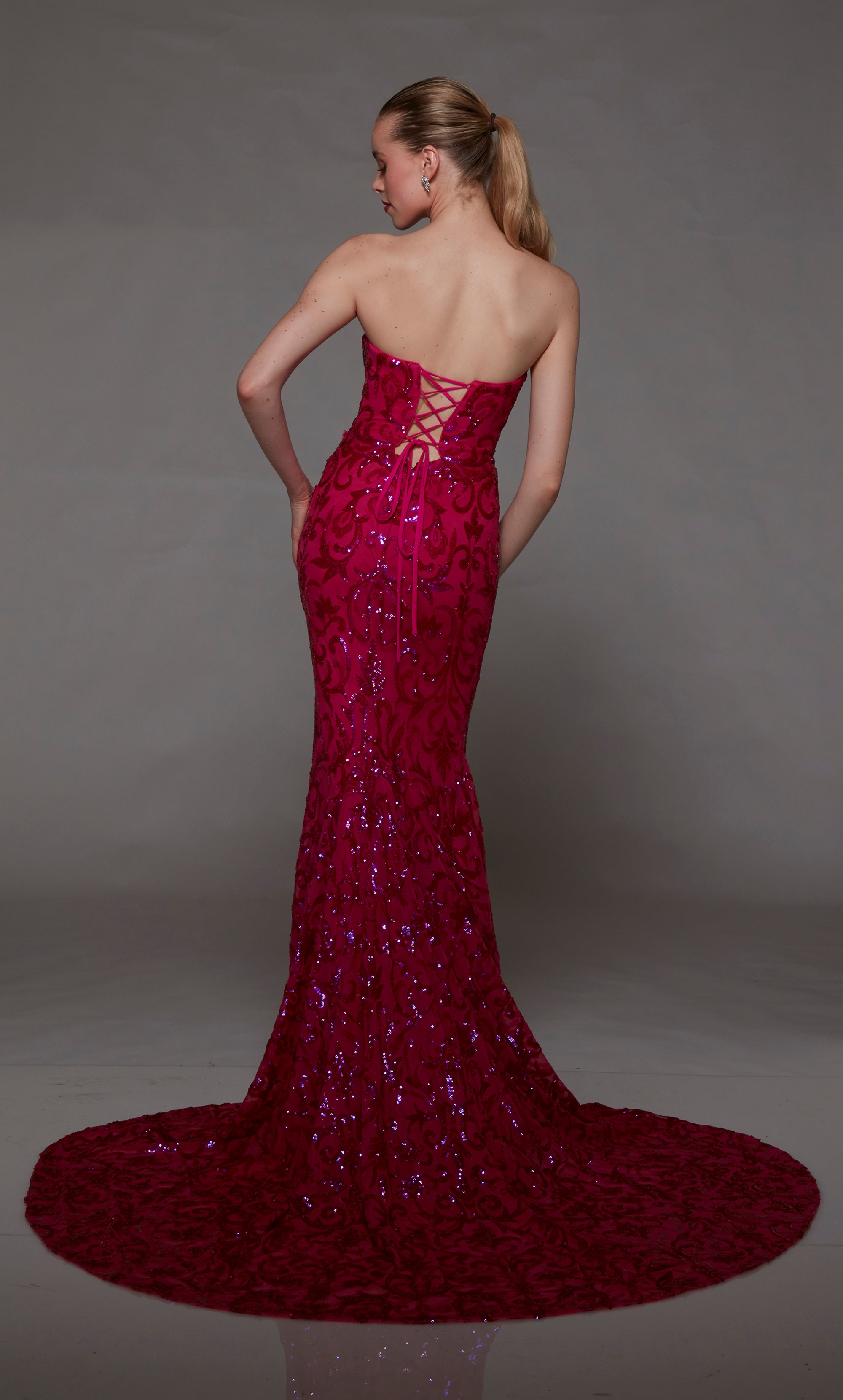 Pink strapless designer dress adorned with delicate sequin embellishments, featuring an lace-up back and an long glamorous train for an truly elegant look.
