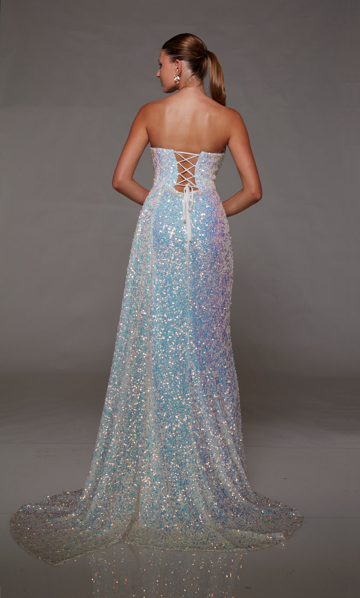 Ivory iridescent sequin gown with an strapless neckline, daring side slit, lace-up back, and side train for an dramatic and glamorous effect.