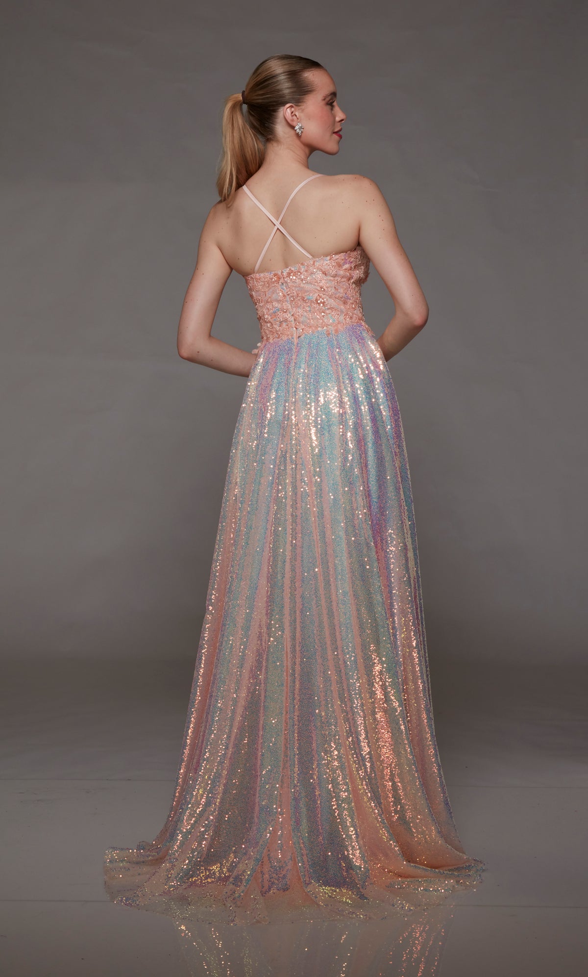Iridescent pink opal sequin designer prom dress with an plunging neckline, floral lace appliques, high slit, zip-up back, crisscross straps, and an train for an captivating look.