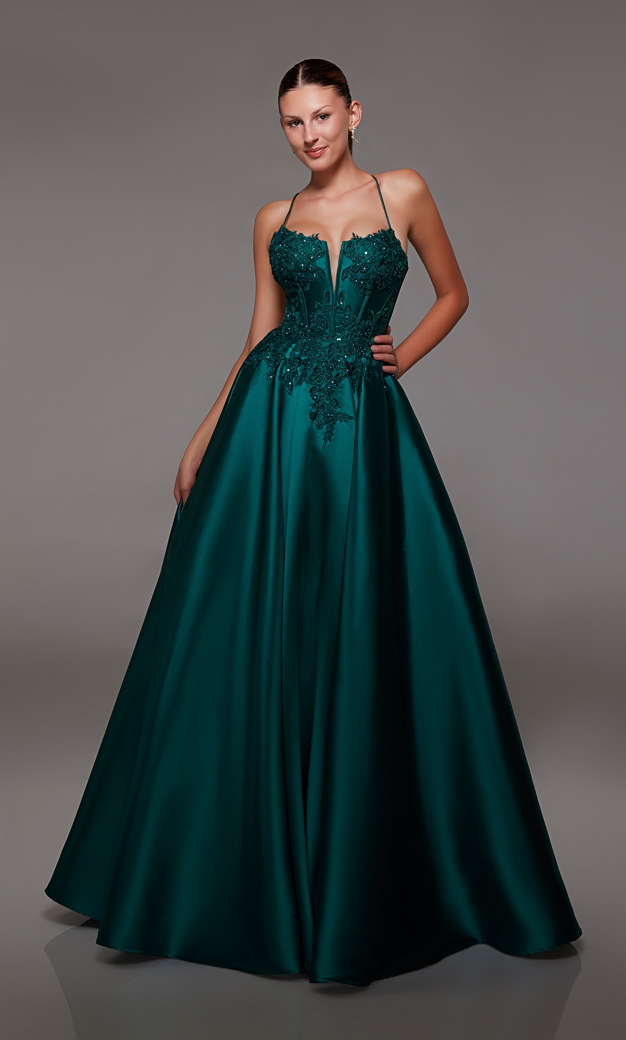 Pine green ball gown spotlighting an plunging corset bodice with beaded floral lace appliques and an strappy lace-up back for an enchanting and stylish look.