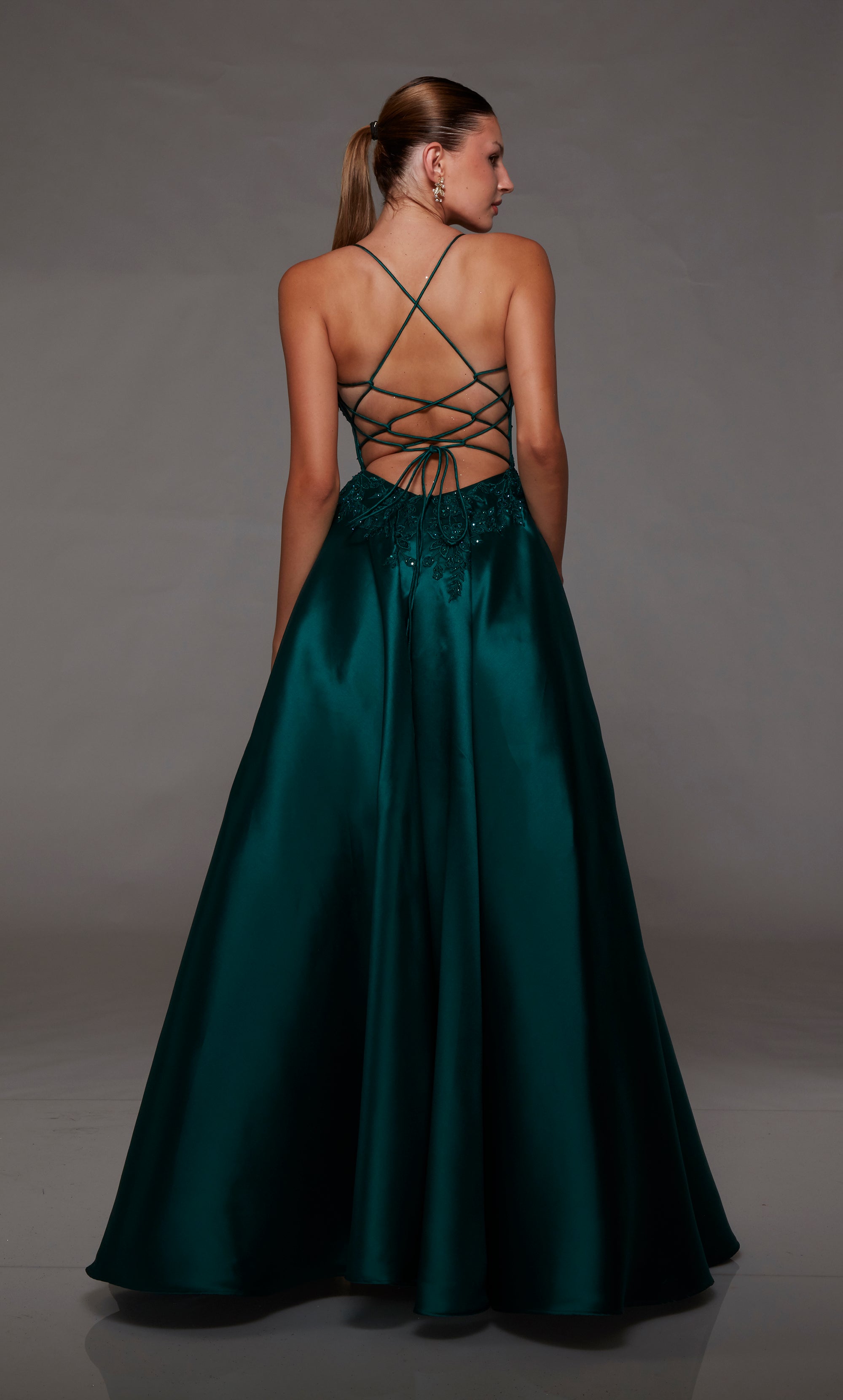 Pine green ball gown spotlighting an plunging corset bodice with beaded floral lace appliques and an strappy lace-up back for an enchanting and stylish look.