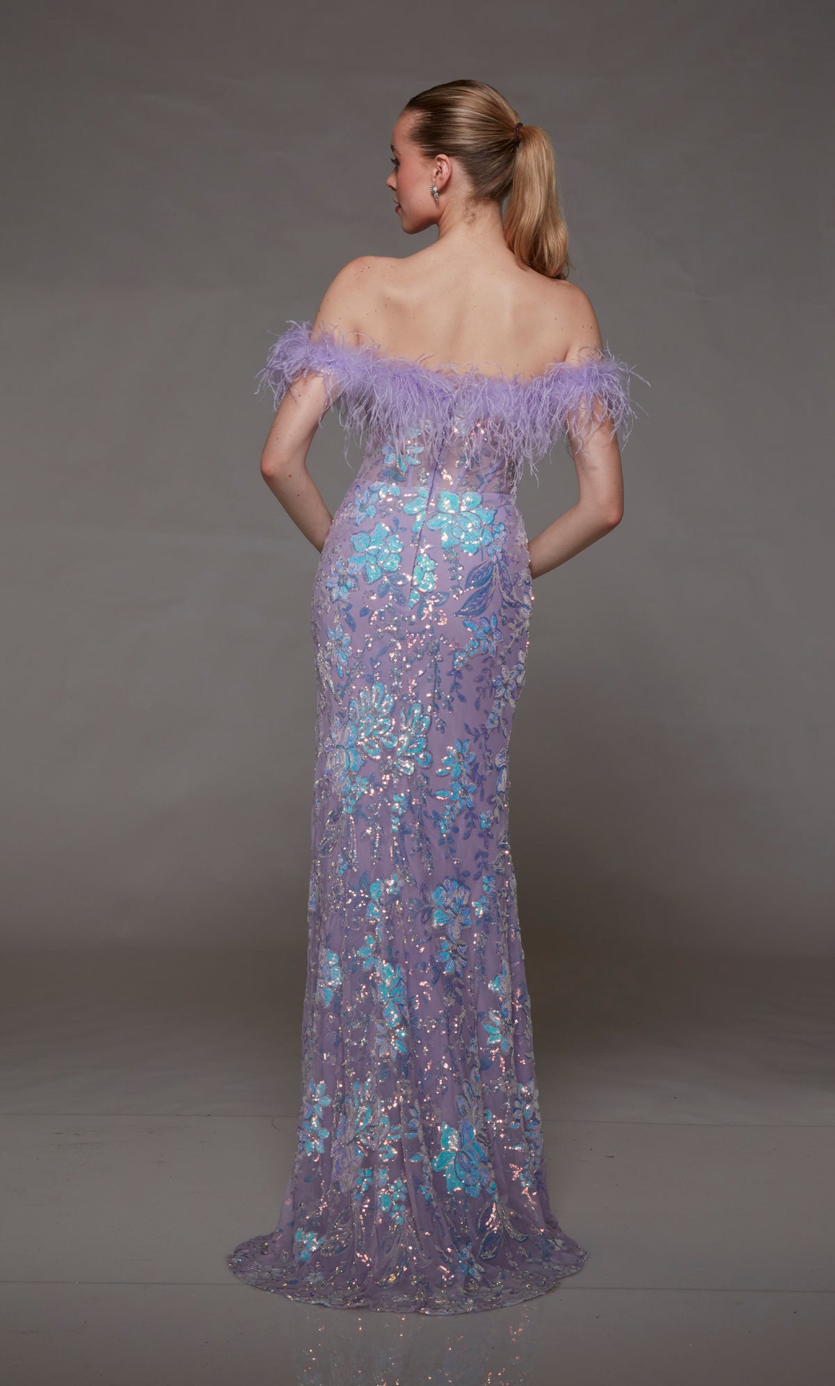 Lilac purple prom dress with feather-trimmed off-the-shoulder neckline, iridescent sequin flowers, side slit, and slight train for an elegant and stylish look.