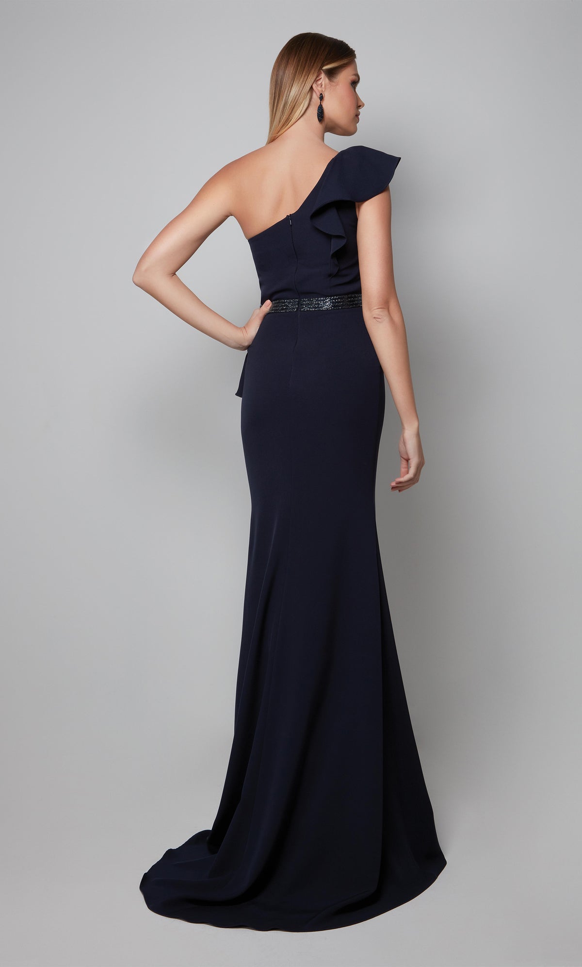 One shoulder ruffle dress with a zip up back, faux beaded belt, and train in midnight blue.