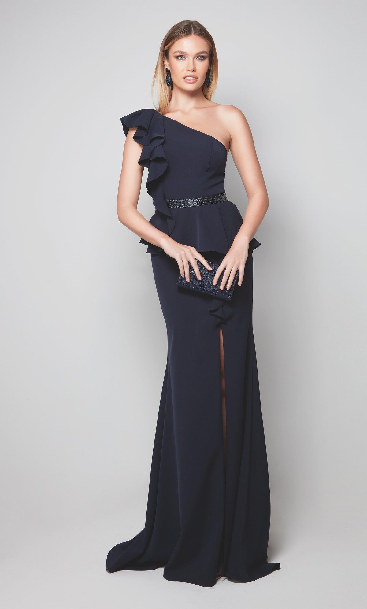 One shoulder formal dress with ruffle detail, faux beaded belt, and side slit in midnight blue.