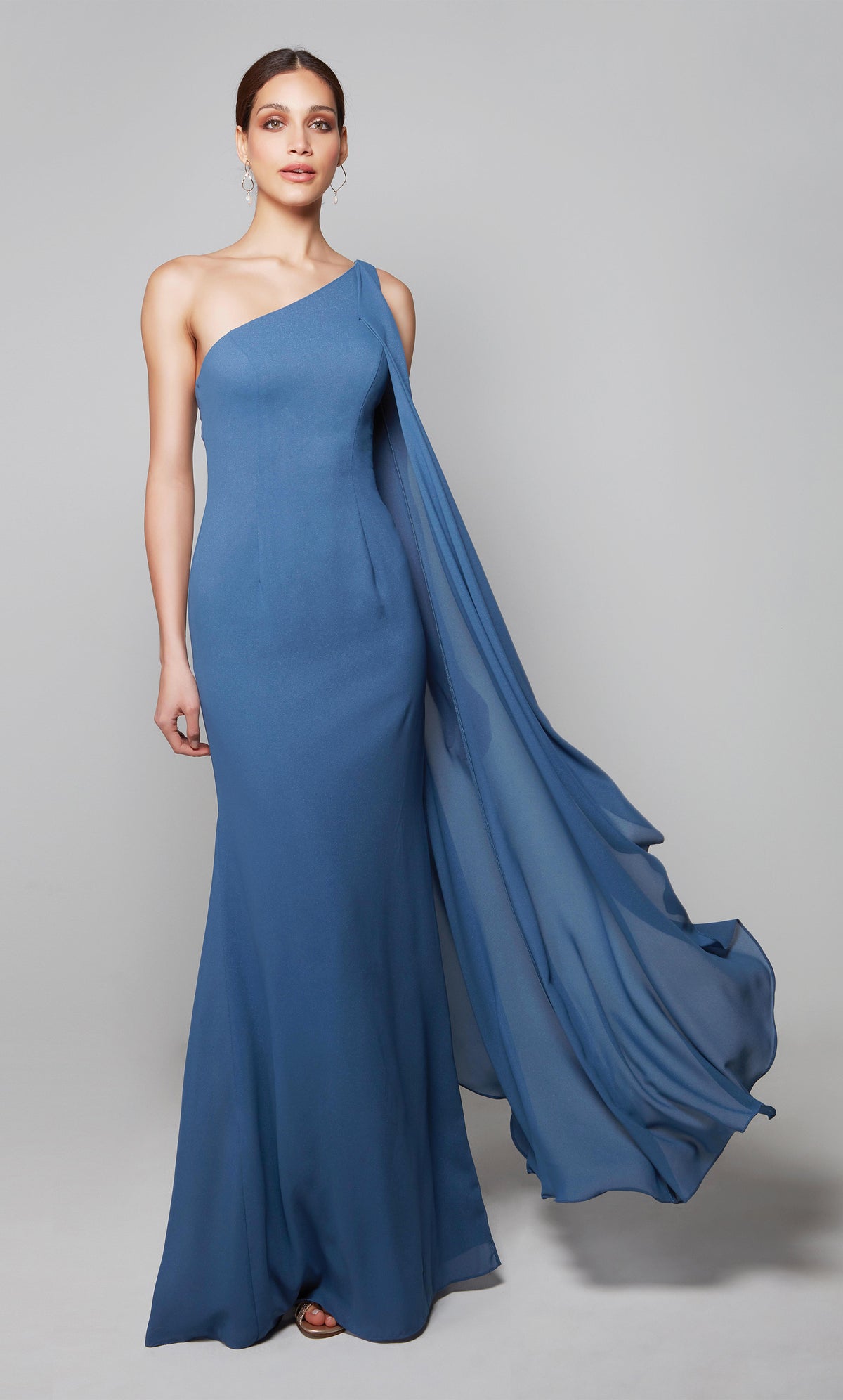 Elegant wedding guest dress with a one shoulder neckline and a wrap hem cape in blue.