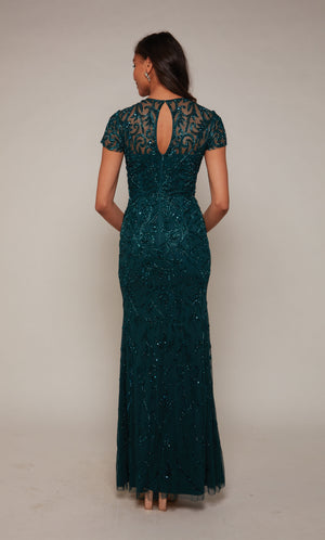 Floor length hand-beaded evening gown with an keyhole back and short sleeves in dark blue-ish green .
