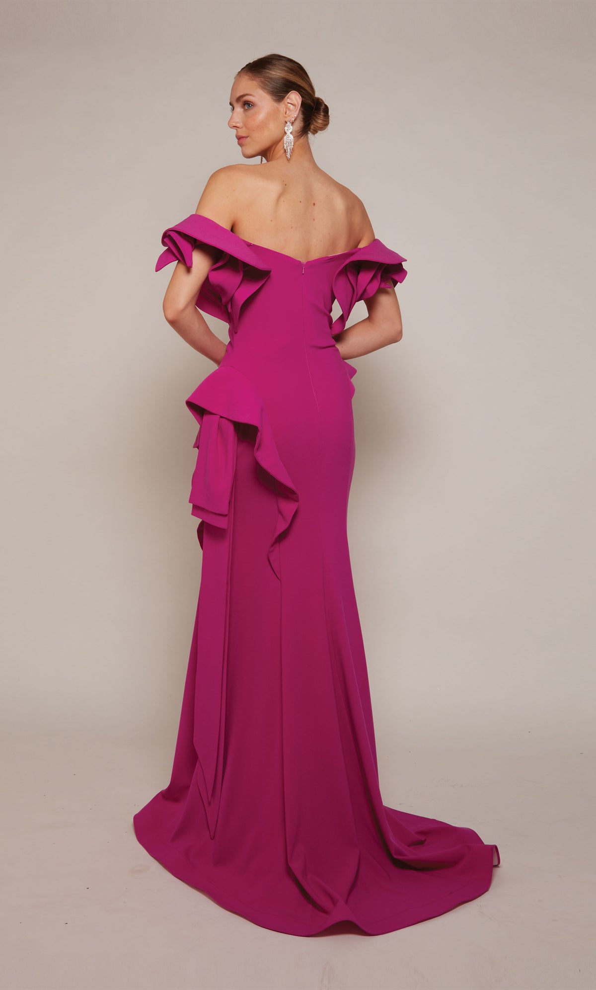 A chic, raspberry pink wedding guest dress boasting an off-the-shoulder neckline, rosette sleeves, and a sheath skirt with cascading ruffles ending in a dramatic train. An excellent choice for a formal evening wedding.