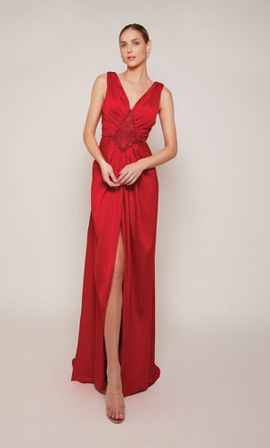 A sleeveless, red satin wedding guest dress with a V-shaped back and dramatic train.