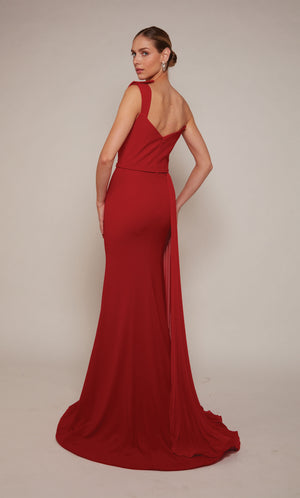 A long formal dress with a one shoulder neckline and side slit in red. The back of the dress has a zip-up closure and an elegant train.