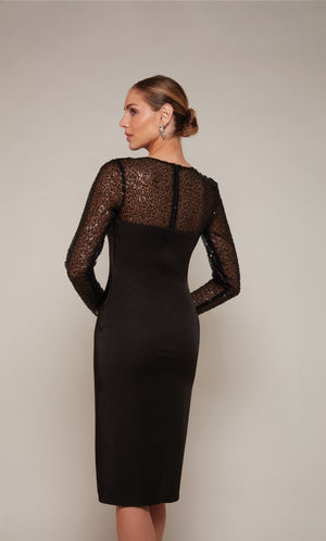 A black satin knee length cocktail dress with long mesh sequin sleeves and a zip-up closed back.