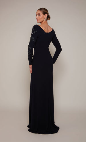 A navy long sleeve mother of the bride dress with an off center V-shaped back, a slight train, and silver beaded detail on the left sleeve.