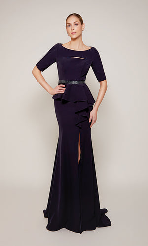 A navy scooped neck designer gown with a peplum short sleeve bodice, a beaded waistline, a side ruffle, and side slit.
