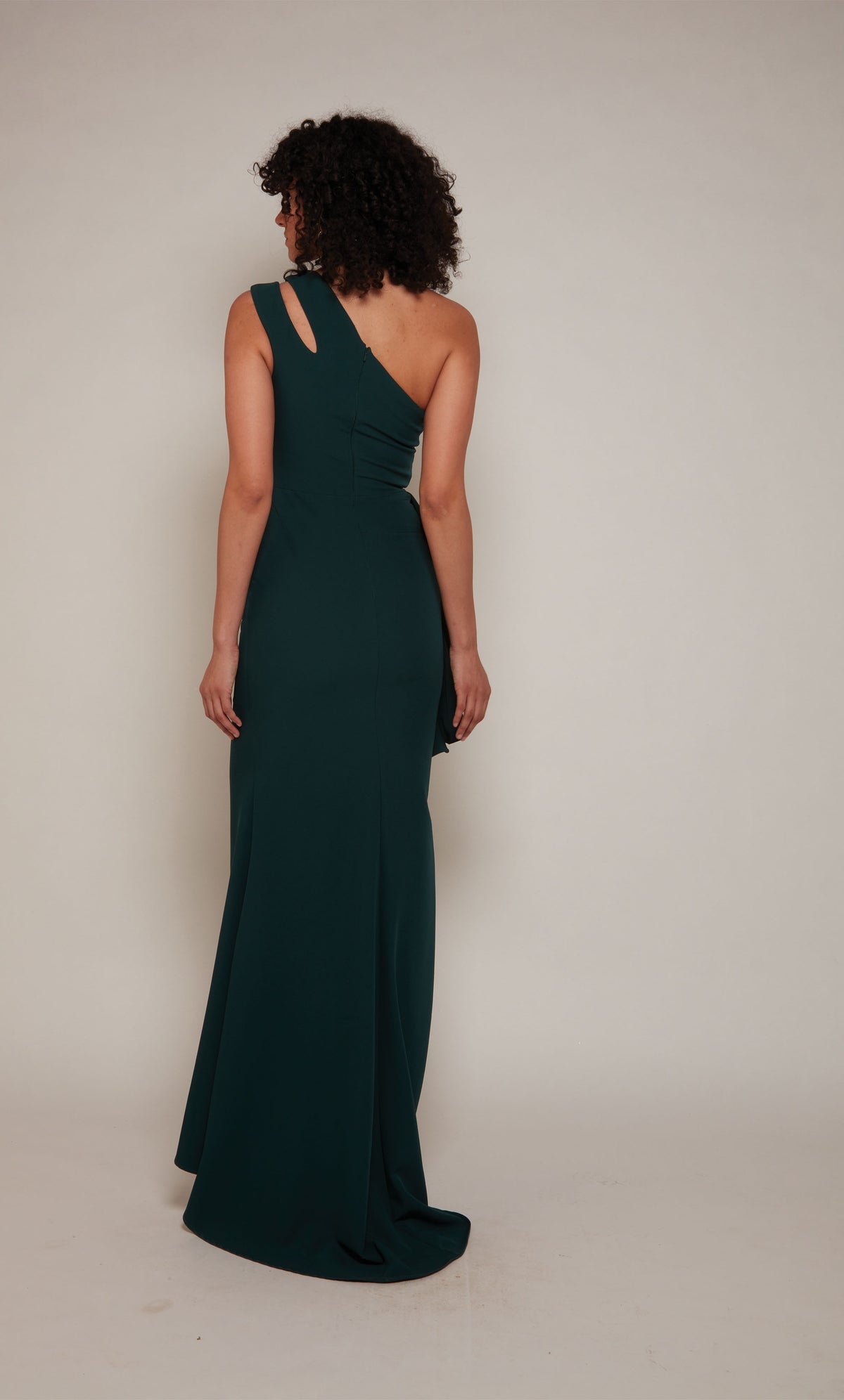 Forest green long evening gown highlighting a cutout, one shoulder neckline, a zip-up back, and slight train.