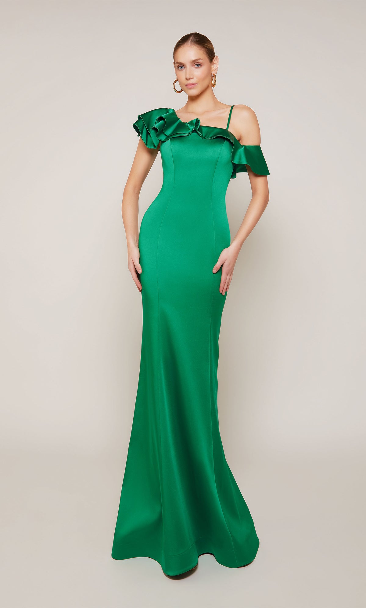 A satin formal dress featuring a one shoulder neckline, a fitted silhouette, and ruffles in emerald green.