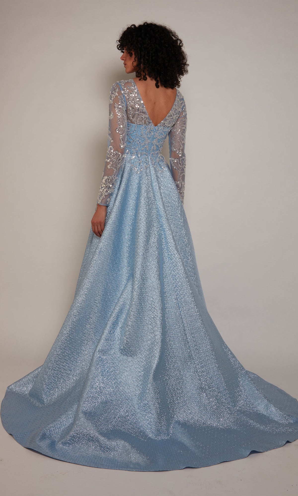 A french blue A-line mother of the bride gown with long sleeves and a long dramatic train. The bodice of the dress has a beautiful embellished tulle overlay.
