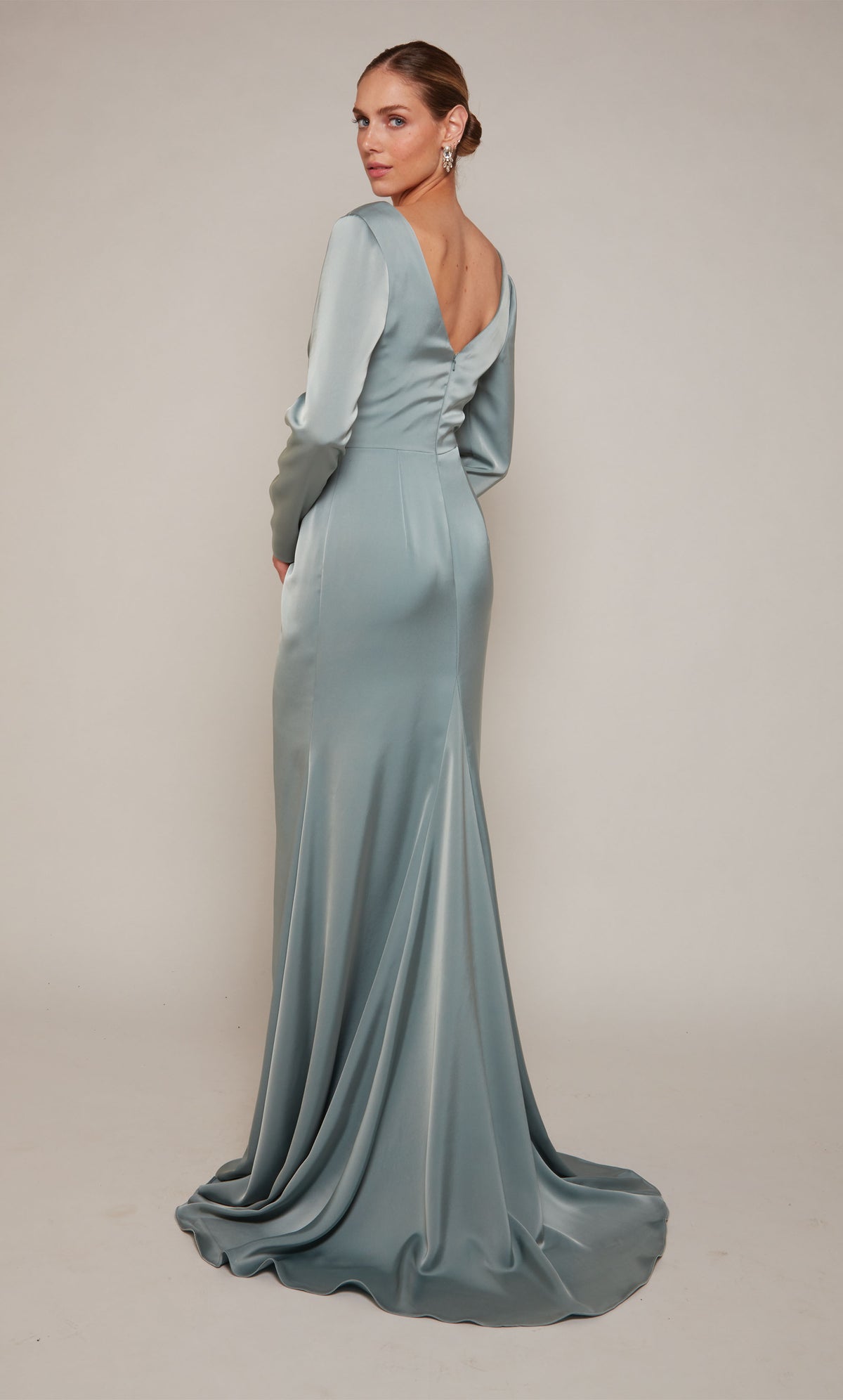 A chic, long sleeve evening gown with a V-shaped back and a train, in a sheen sage green color.
