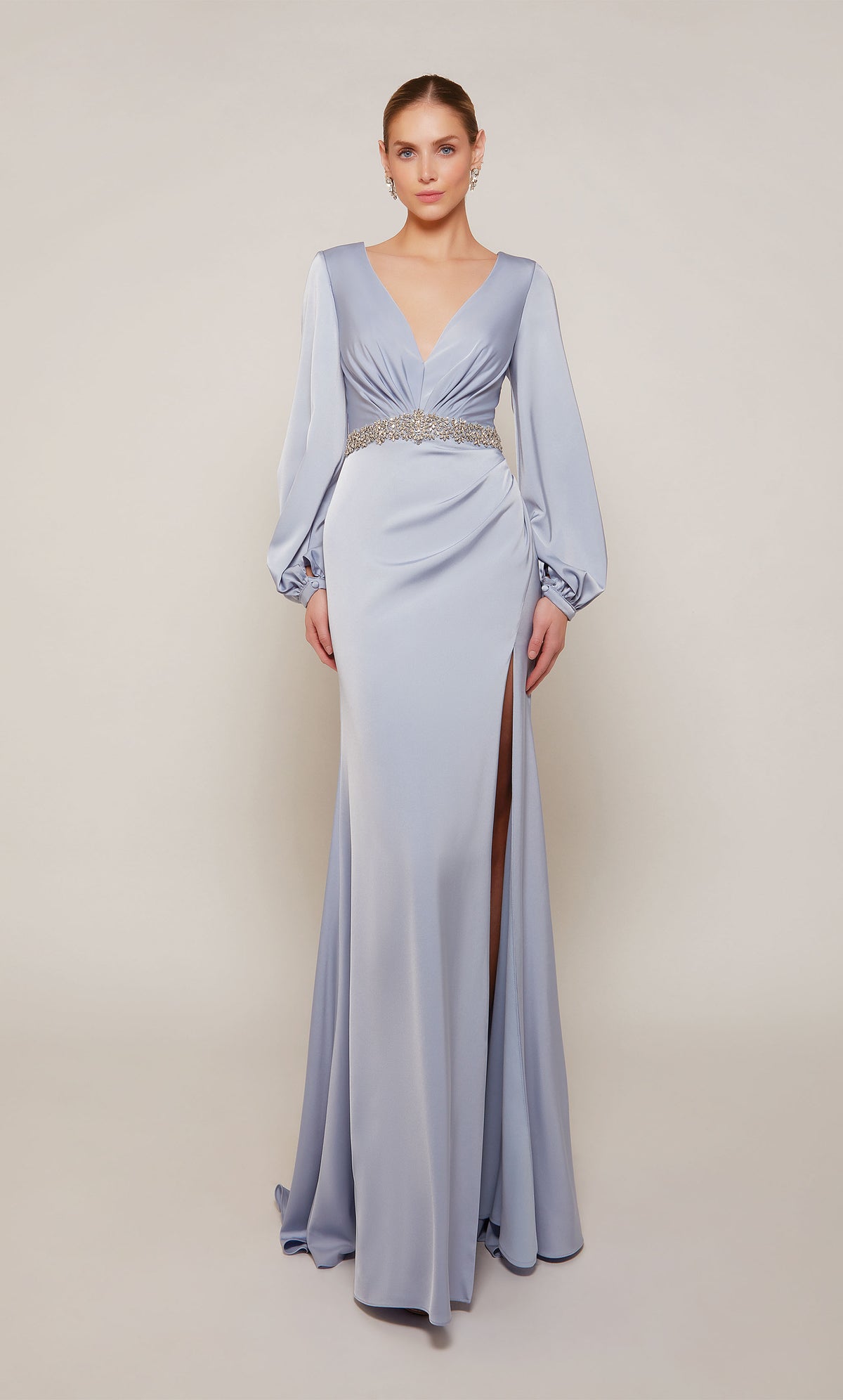 A chic, long sleeve, satin mother of the bride dress with a V-neckline, jeweled waistline, and side slit in french blue.