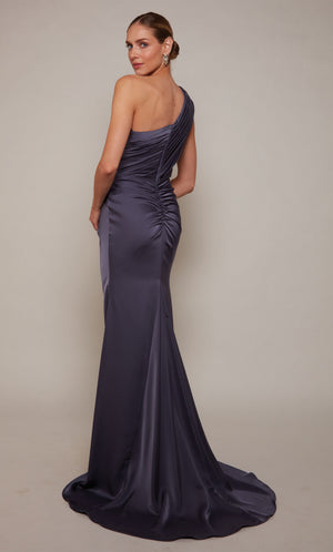 An elegant, satin one shoulder gown with ruching detail, a closed zipper back, and train in a purple-ish grey color called storm cloud.