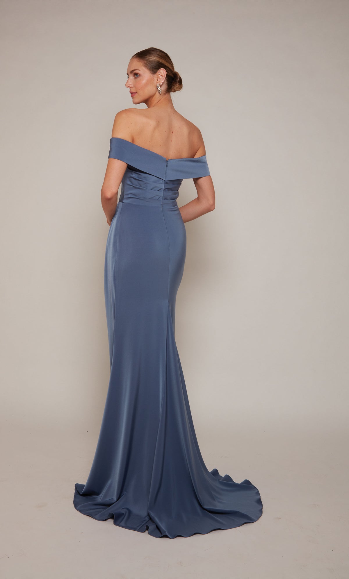 A sophisticated, off-the-shoulder wedding guest dress with a pleated waist and fit and flare silhouette in dark french blue.