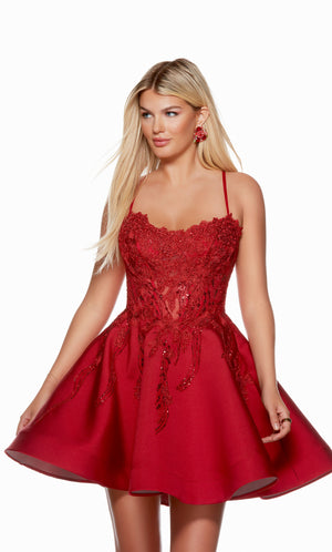 A red corset dress with a sheer lace bodice, a flared skirt, and a lace-up back, perfect for parties or dances. This dress is from our latest collection of gorgeous designer dresses by ALYCE Paris.