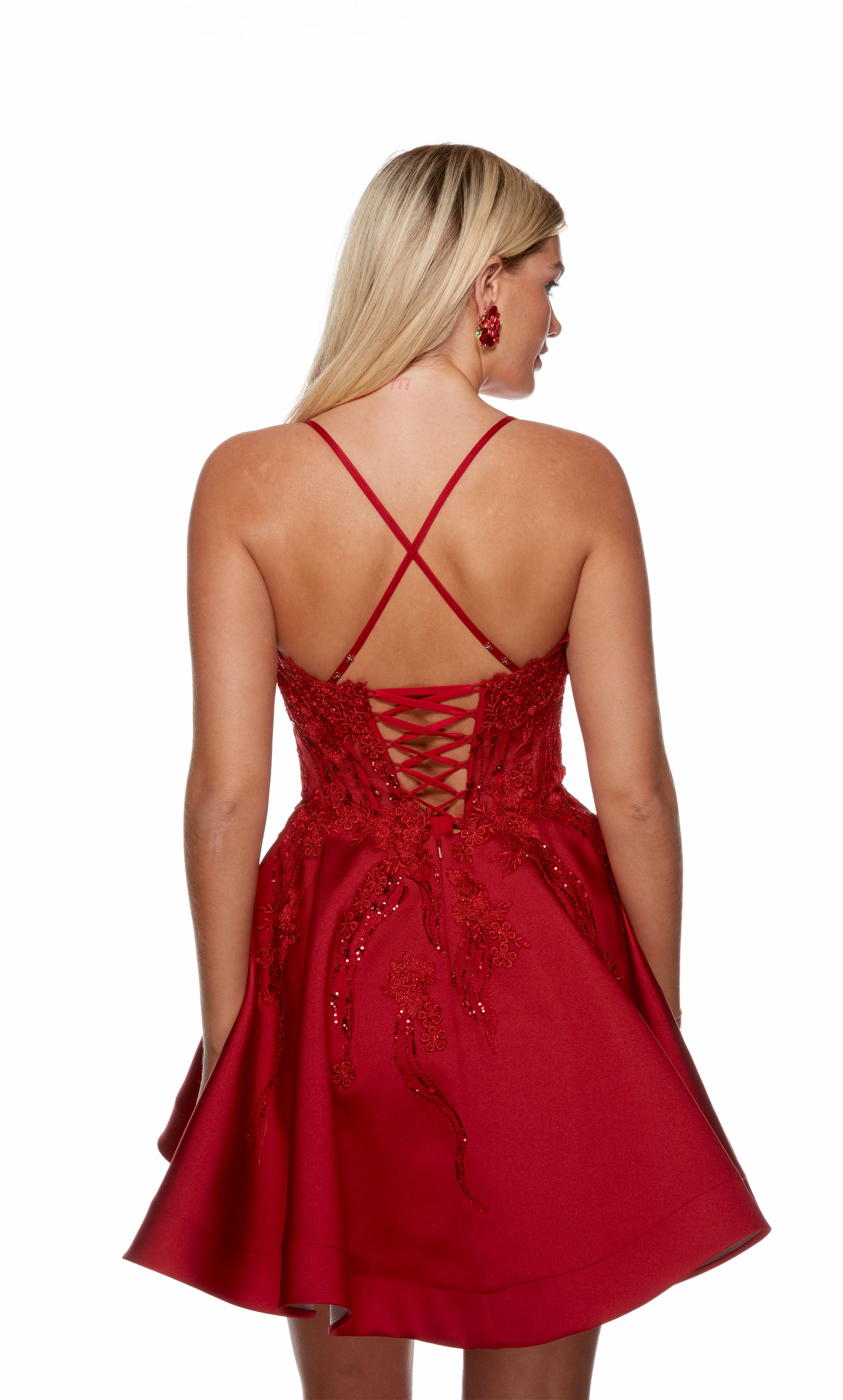 A red corset dress with a sheer lace bodice, a flared skirt, and a lace-up back, perfect for parties or dances. This dress is from our latest collection of gorgeous designer dresses by ALYCE Paris.