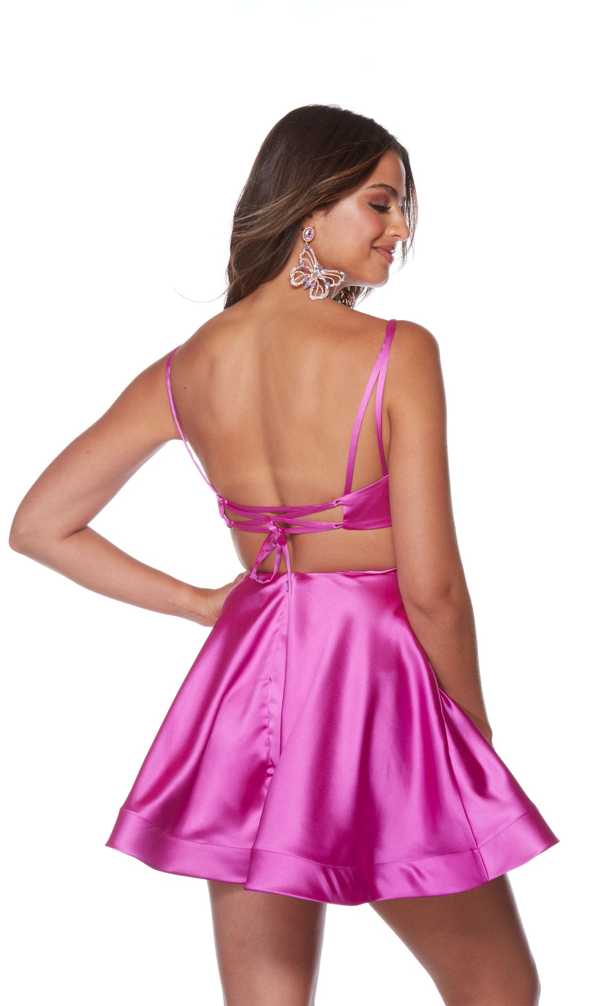 A V-neck, short satin homecoming dress with double spaghetti straps and a strappy, lace-up back in the color neon purple.