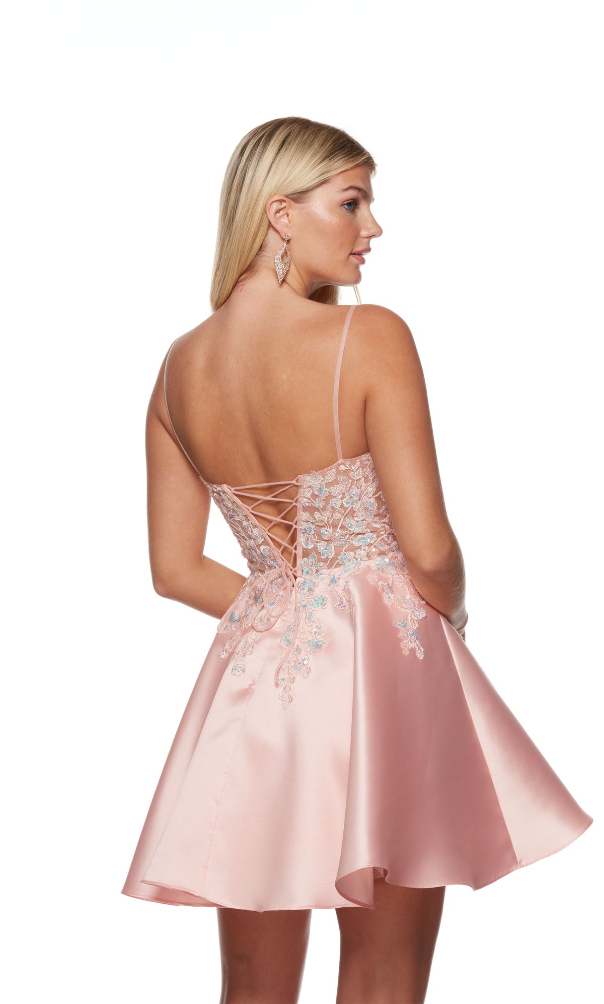 A blush pink short party dress featuring a sheer lace bodice, adorned with intricate floral lace appliques and a lace-up back.
