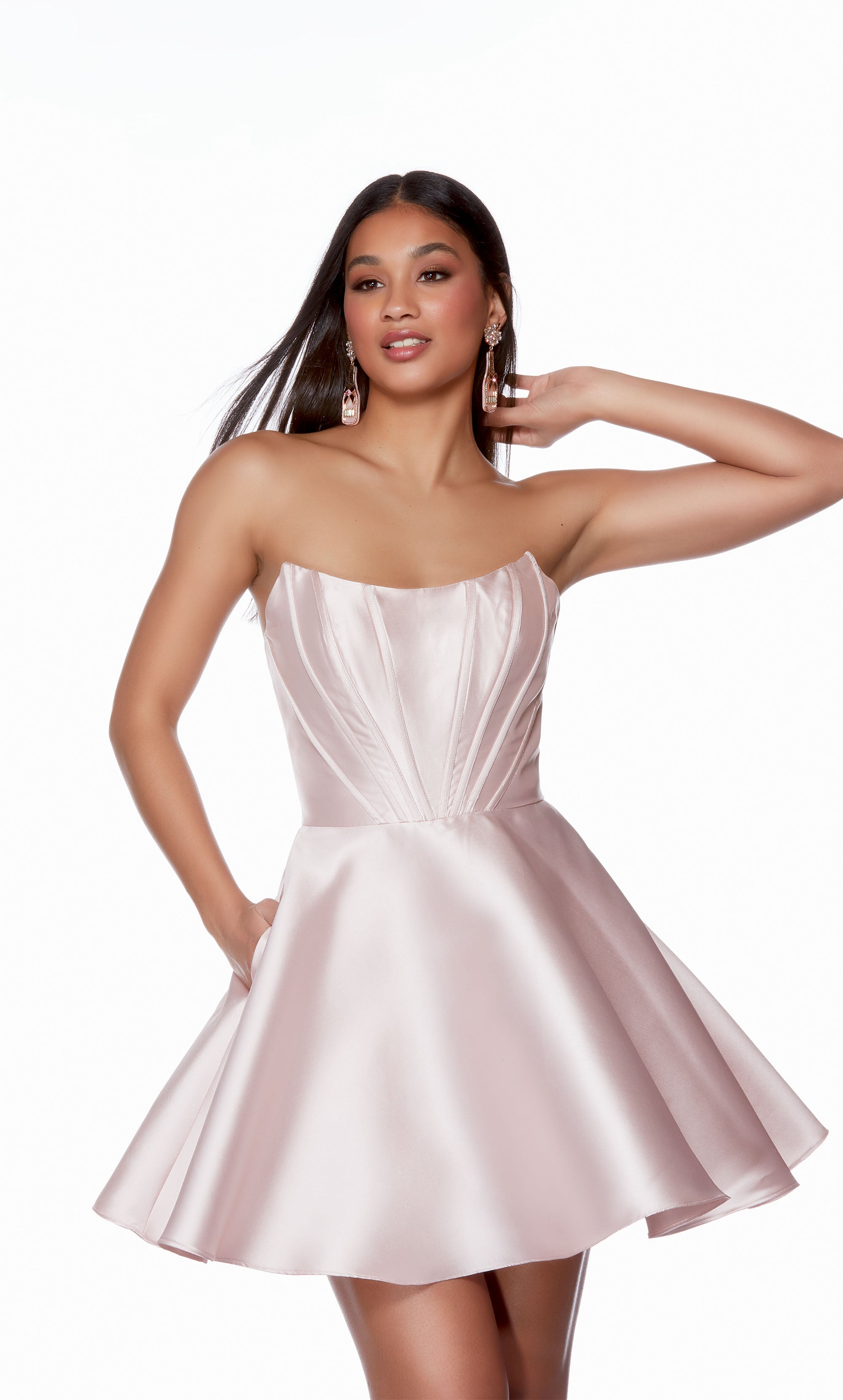 A modern and trendy short formal dress, featuring a strapless corset bodice and flirty flared skirt with pockets, perfect for dancing the night away.