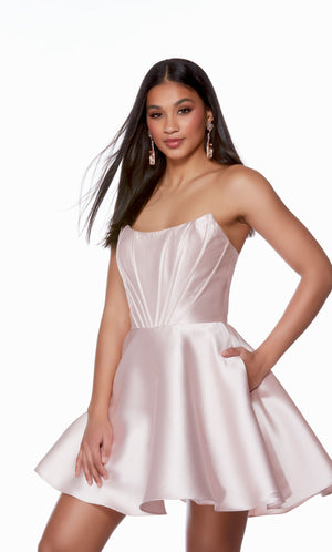 A modern and trendy short hoco dress, featuring a strapless corset bodice and flirty flared skirt with pockets, perfect for dancing the night away.