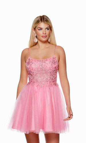 A romantic short prom dress in light pink. The dress has a scooped neckline and a lace overlay on the bodice, adorned with delicate floral appliques. The skirt is made of multi layered glitter tulle for the perfect touch of sparkle.