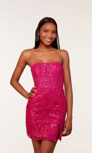 A short strapless corset dress with a sheer bodice adorned with an intricate lace overlay and a side slit. The dress was created in a rich raspberry color.