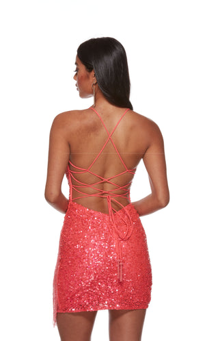 A glamorous short prom dress in iridescent hyper-pink sequins. The dress features a strappy open back and beaded fringe, adding interest to the look.