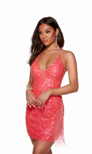 A glamorous short prom dress in iridescent hyper-pinker sequins. The dress features a low neckline and beaded fringe, adding interest to the look.