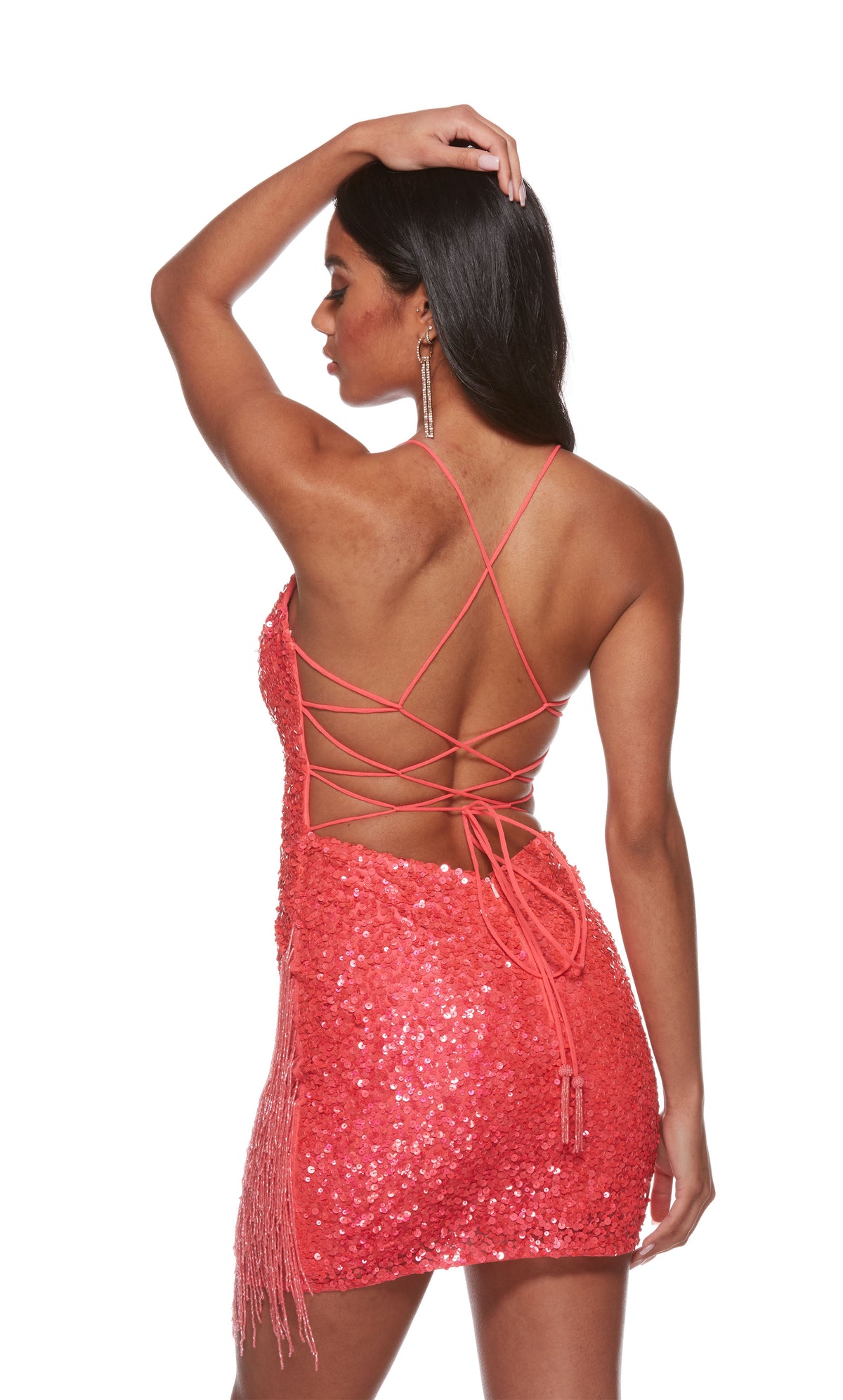 A glamorous short prom dress in iridescent hyper-pink sequins. The dress features a low neckline and beaded fringe, adding interest to the look.