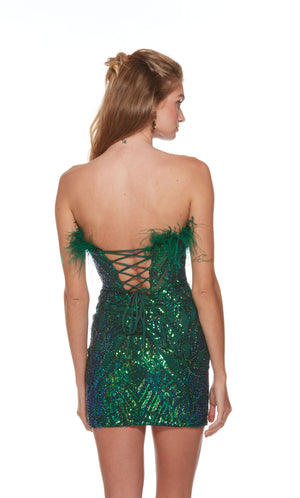 An iridescent sequin short prom dress with a lace up back and feather trim in pine green.