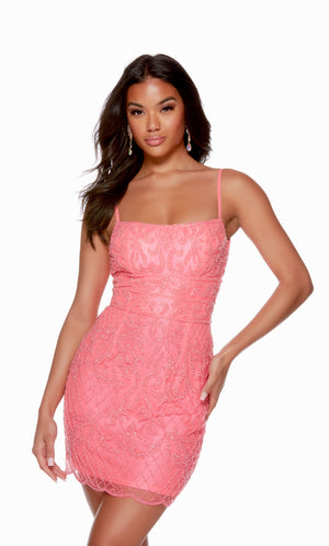 A light neon pink,, hand-beaded short homecoming dress with a slightly scooped neckline, spaghetti straps, and a scalloped hemline.