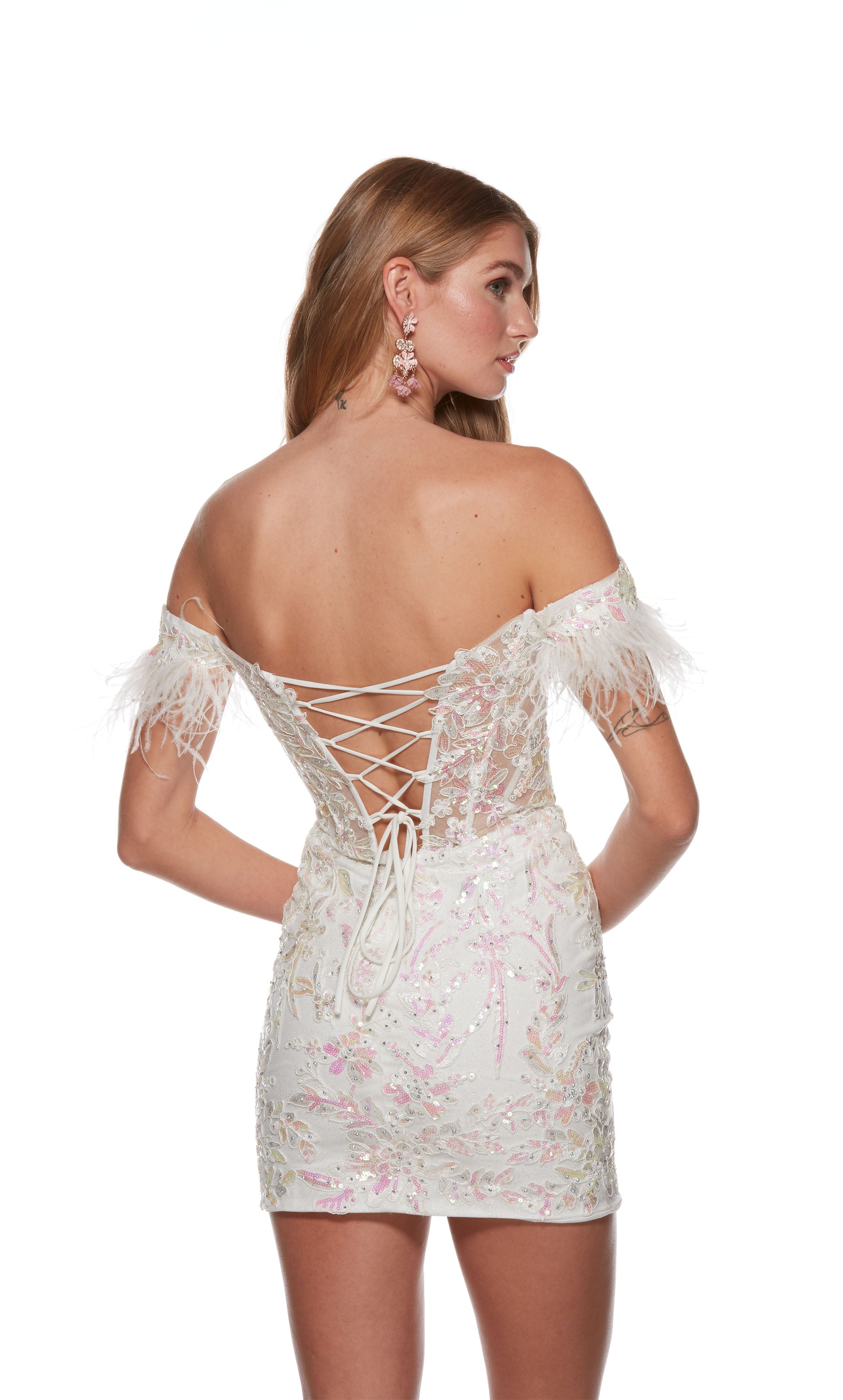 A white, lace-up back corset dress featuring a sheer bodice, feather adorned sleeves, and pink iridescent sequin embellished floral appliques throughout.