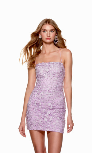 A darling light purple short homecoming dress with a straight across neckline, delicate floral embroidery, and matching gem stones, adding the perfect amount of sparkle.