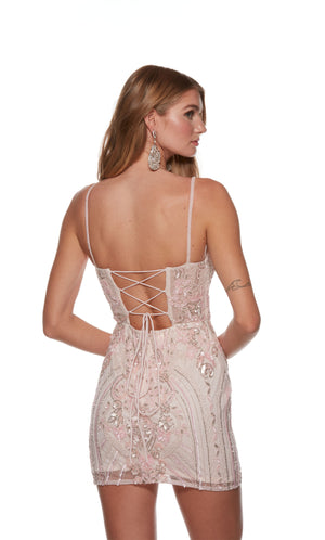 A hand beaded rosewater pink colored short homecoming dress with a lace-up back, adorned with multi-colored beads for a little sparkle.