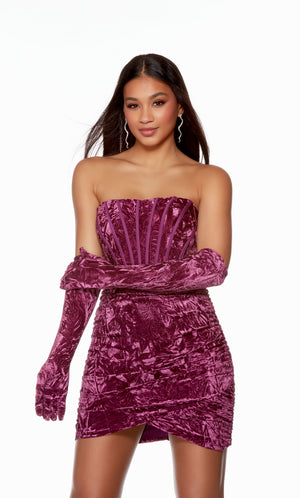 A fun, magenta-colored velvet corset dress with a strapless neckline and a ruched, asymmetrical skirt. The matching gloves level up this chic look.